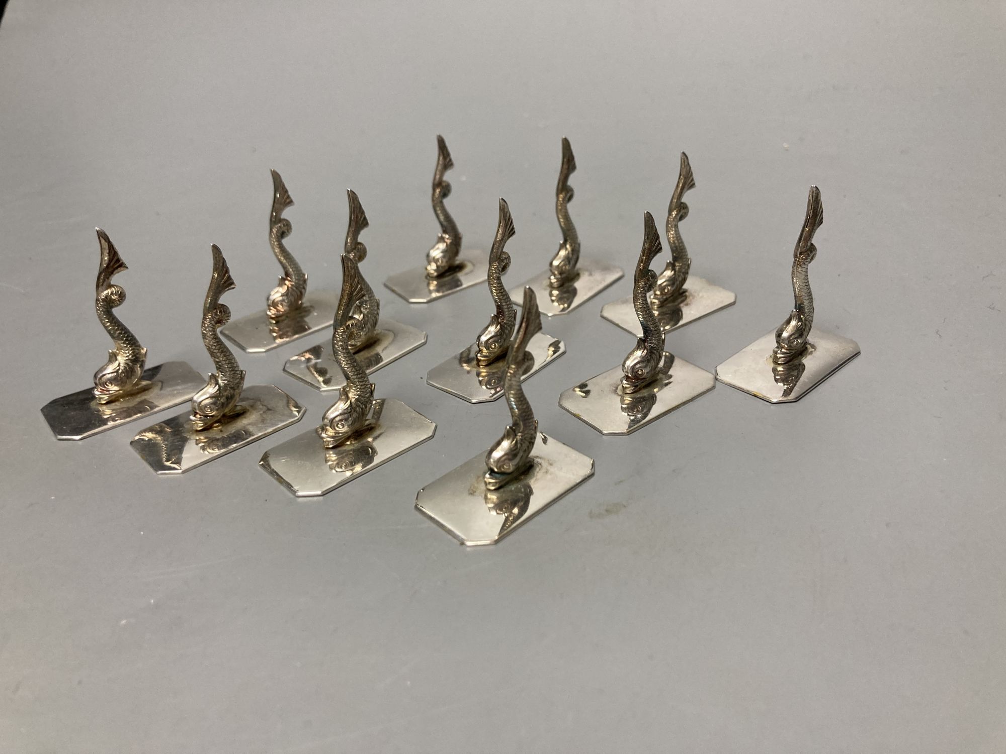 A set of twelve Portugese silver dolphin place/menu holders, height 4cm